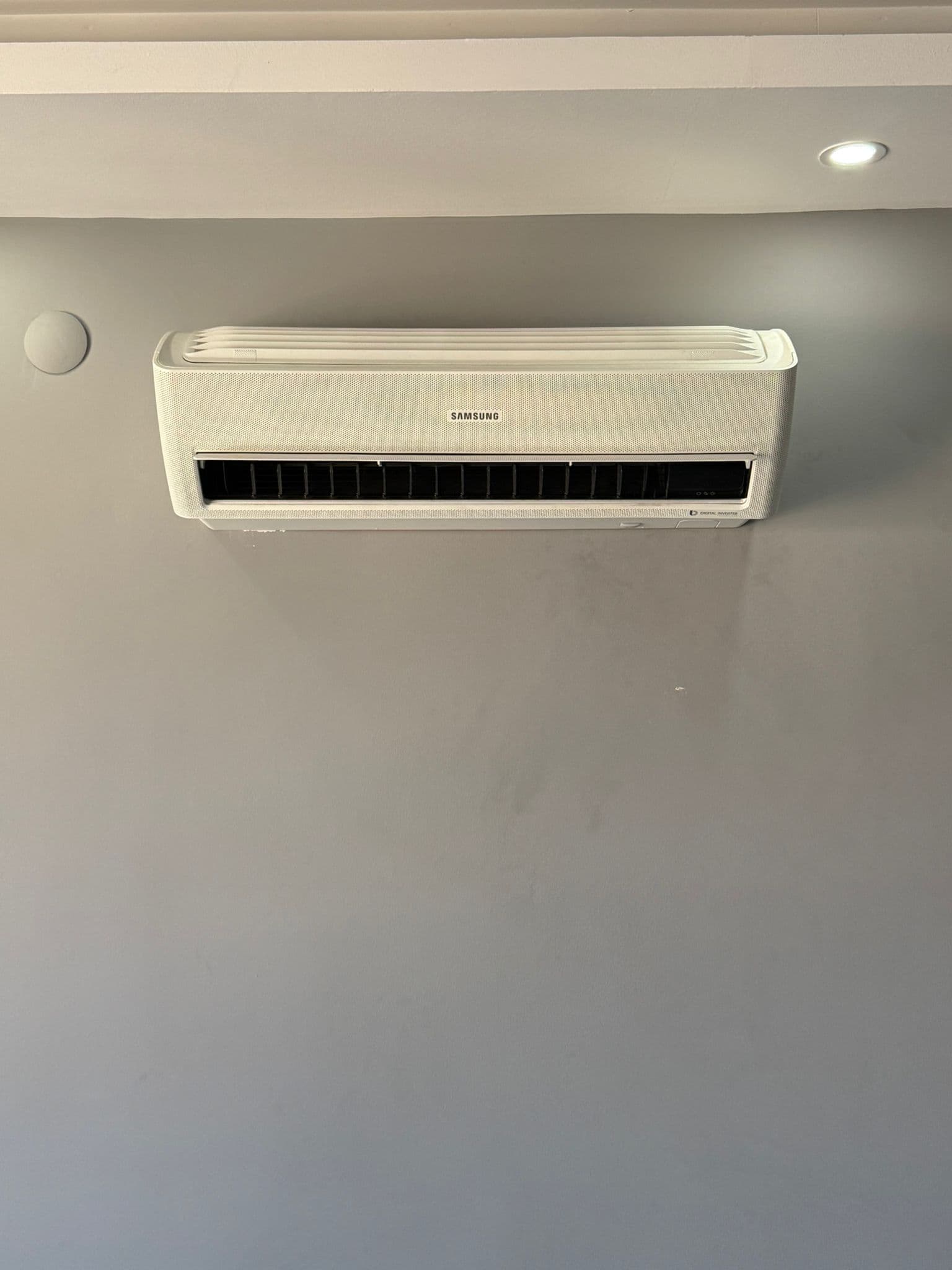 Gri duvara monte edilmiş, tesisatı tamamen gizlenmiş Samsung Digital Inverter duvar tipi iç ünite